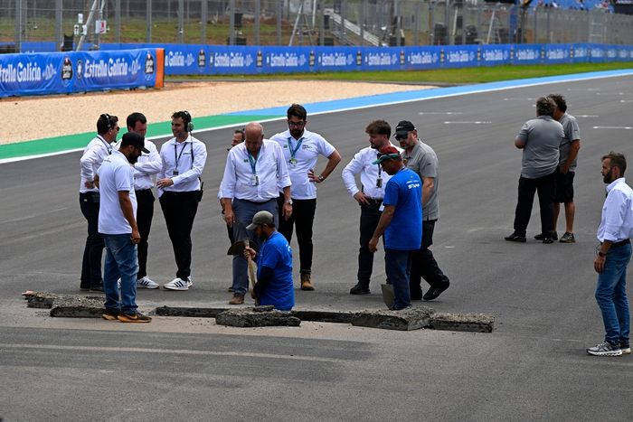 Officials repair a sinkhole on the start finish straight