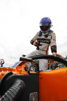 Fernando Alonso, McLaren, climbs out of his car on the grid