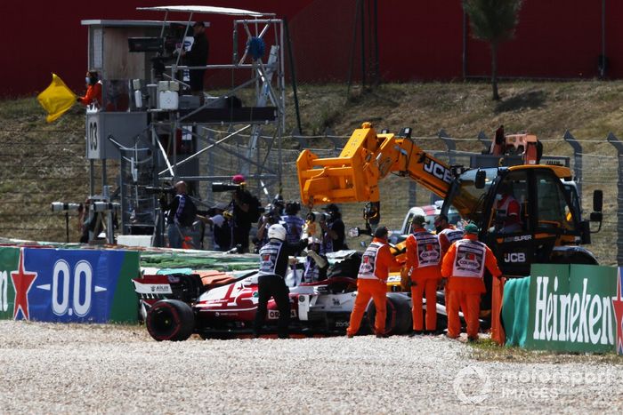 Los oficiales de pista trabajan para recuperar el coche de Kimi Raikkonen, Alfa Romeo Racing C41 
