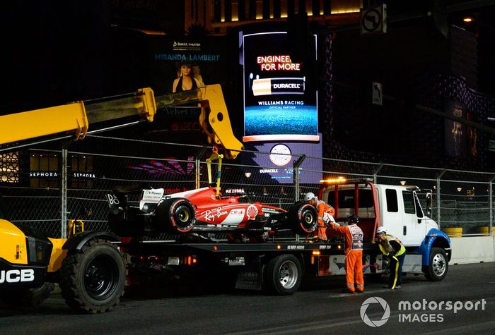 Los comisarios cargan el coche dañado de Carlos Sainz, Ferrari SF-23, en un camión