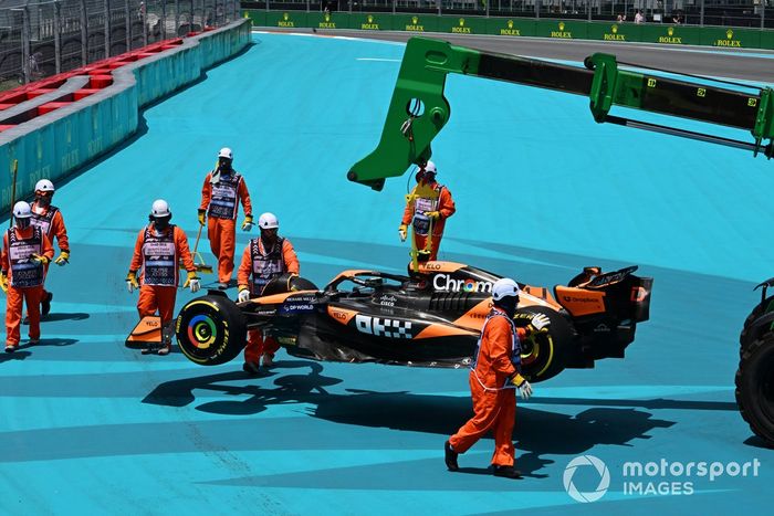 Los comisarios retiran el coche de Lando Norris, McLaren MCL38, después de que hiciera un trompo en la primera vuelta