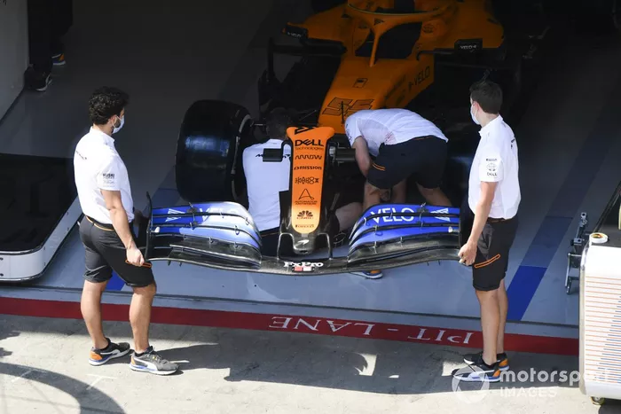 Mecánicos de McLaren instalando el alerón delantero en el coche de Carlos Sainz Jr., McLaren MCL35 