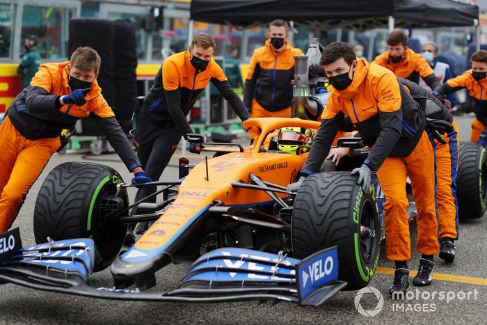 Los mecánicos empujan el coche de Lando Norris, McLaren MCL35M, en la parrilla de salida