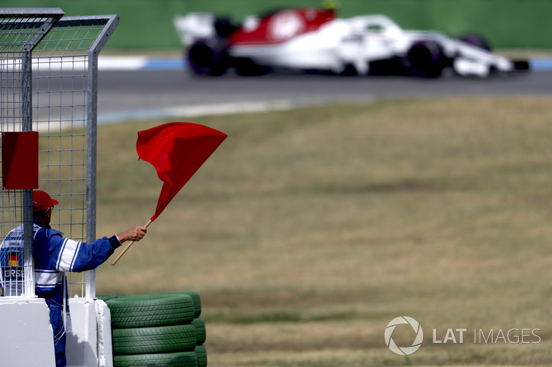A marshal waves a red flag