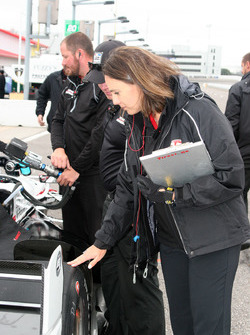 Cara Adams, ingeniero jefe para el Firestone Racing, inspecciona un neumático en Josef Newgarden, co