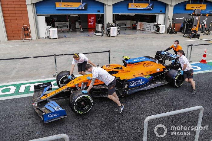 Mecánicos de McLaren llevan el coche por el pitlane de Turquía