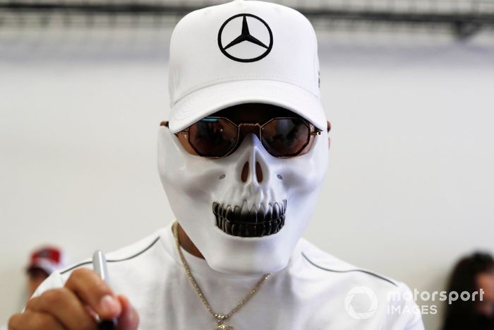Lewis Hamilton, Mercedes AMG F1, con máscara de calavera, firma autógrafos para jóvenes fanáticos