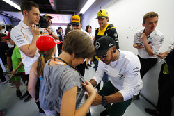 Lewis Hamilton, Mercedes AMG F1, signe le short d'un enfant sous les yeux de Carlos Sainz Jr., Renault Sport F1 Team, Fernando Alonso, McLaren et Stoffel Vandoorne, McLaren, look on