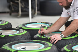 Un mécanicien Mercedes AMG F1 marque des pneus Pirelli