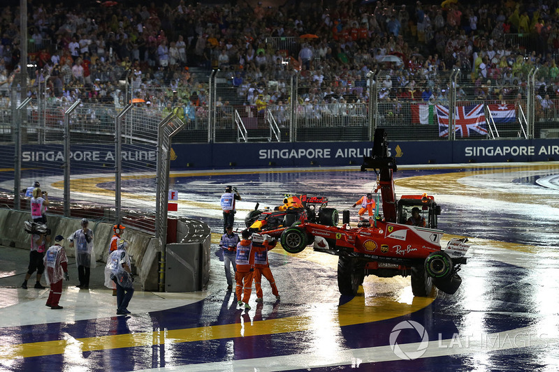 The crashed cars of Max Verstappen, Red Bull Racing RB13 and Kimi Raikkonen, Ferrari SF70H are recovered