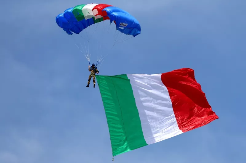 Le parachutiste arrive en arborant le drapeau italien
