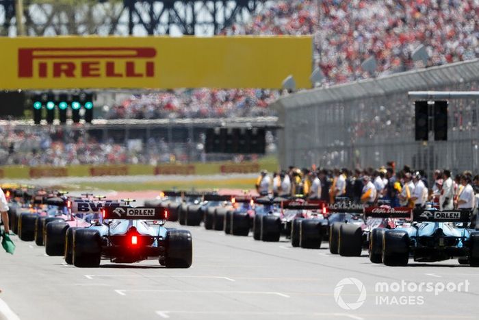 Los mecánicos limpian la parrilla antes del inicio de la vuelta de formación