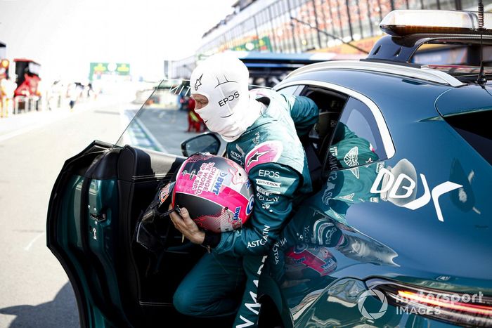 Sebastian Vettel, Aston Martin, es llevado a la calle de boxes por el coche médico