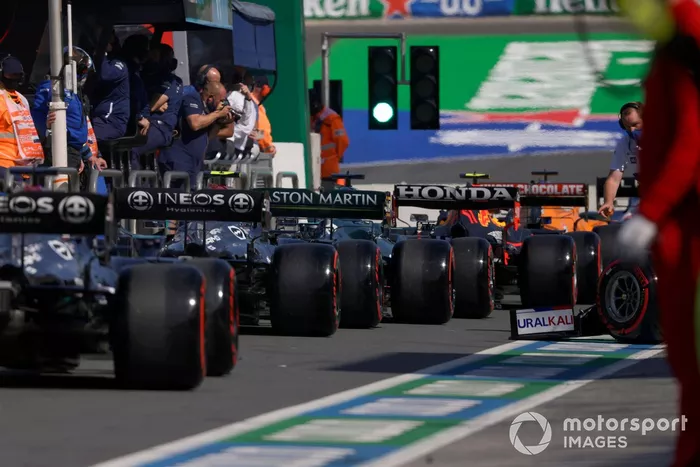 Lance Stroll, Aston Martin AMR21, y Valtteri Bottas, Mercedes W12, en el pit lane