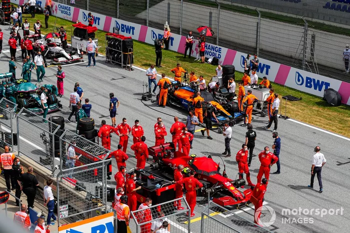 Mecánicos en la parrilla con Carlos Sainz Jr., Ferrari SF21, y Daniel Ricciardo, McLaren MCL35M