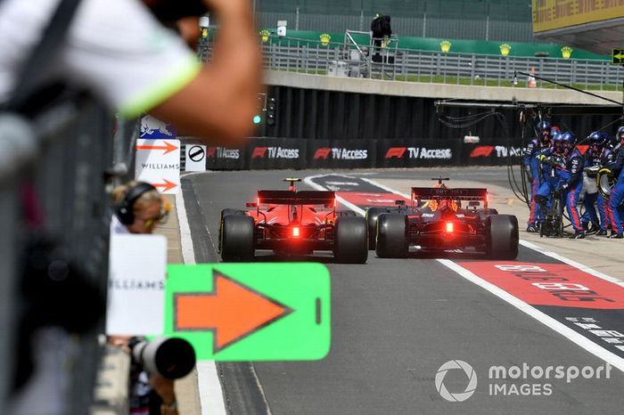 Max Verstappen, Red Bull Racing RB15, y Charles Leclerc, Ferrari SF90, corren para ser los primeros en salir del pit lane