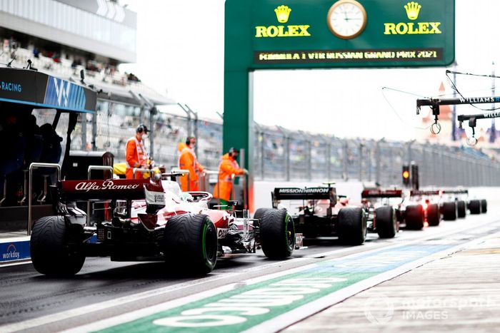 Carlos Sainz Jr., Ferrari SF21, Antonio Giovinazzi, Alfa Romeo Racing C41, en el pit lane