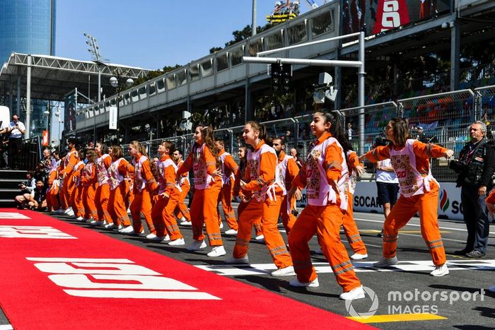 Oficiales de pista bailan antes de la carrera