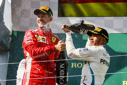 Sebastian Vettel, Ferrari celebra rociando champán en el podio con Lewis Hamilton, Mercedes AMG F1