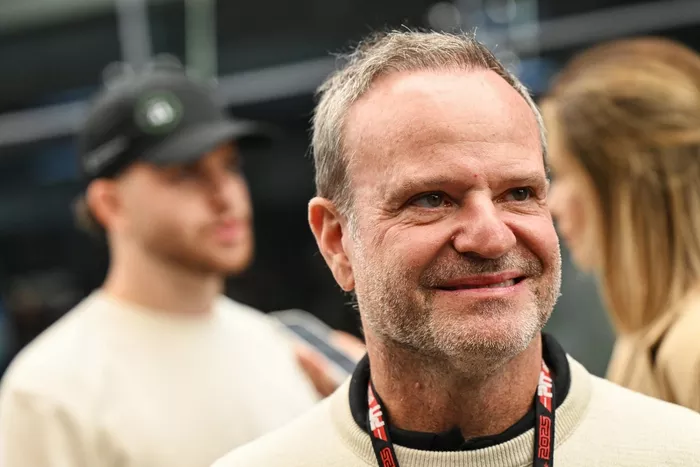 Rubens Barrichello looks on in the Paddock