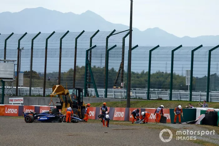 Les commissaires récupèrent la voiture endommagée de Logan Sargeant, Williams FW46, après un accident en FP1.