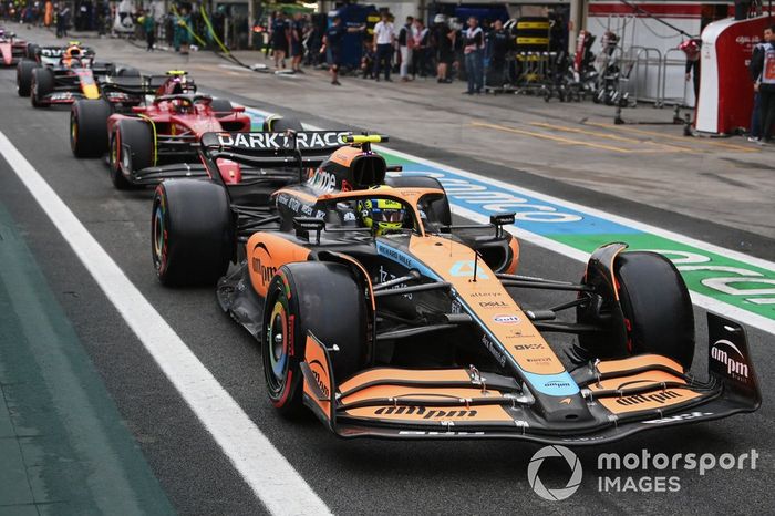 Lando Norris, McLaren MCL36, Carlos Sainz, Ferrari F1-75, Sergio Pérez, Red Bull Racing RB18, en el pit lane