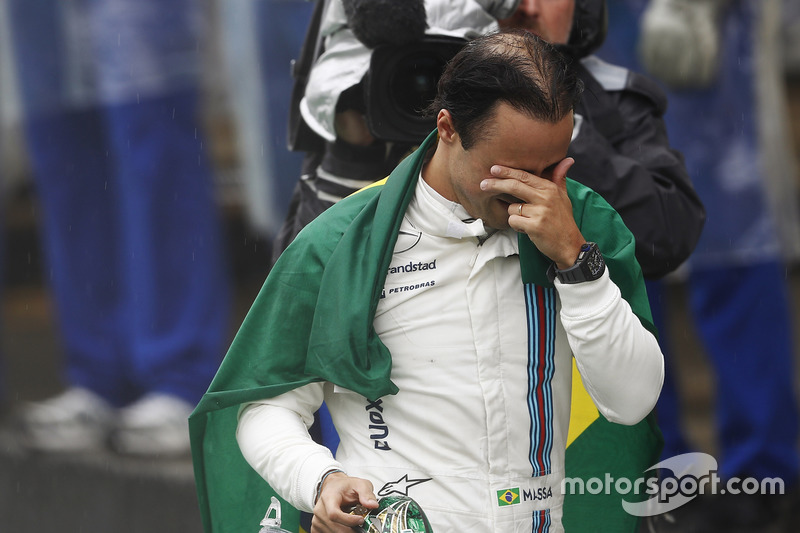 Felipe Massa, Williams, carries a Brazilian flag as he walks back to his garage in tears after crashing