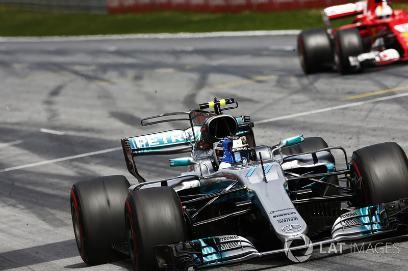 Valtteri Bottas, Mercedes AMG F1 W08, raises an arm in victory celebration at the finish, ahead of S