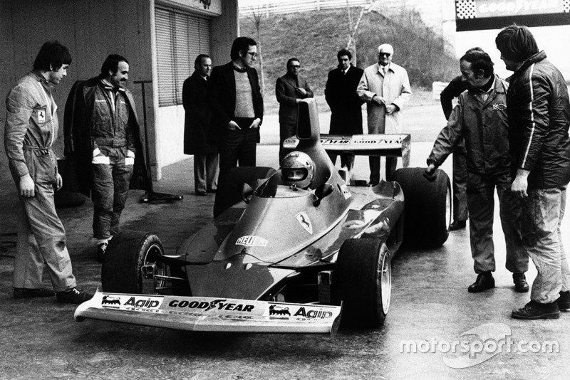 Niki Lauda test de Ferrari 312T voor het eerst als Clay Regazzoni, Mauro Forghieri, Enzo Ferrari en Ermanno Cupghi toekijken
