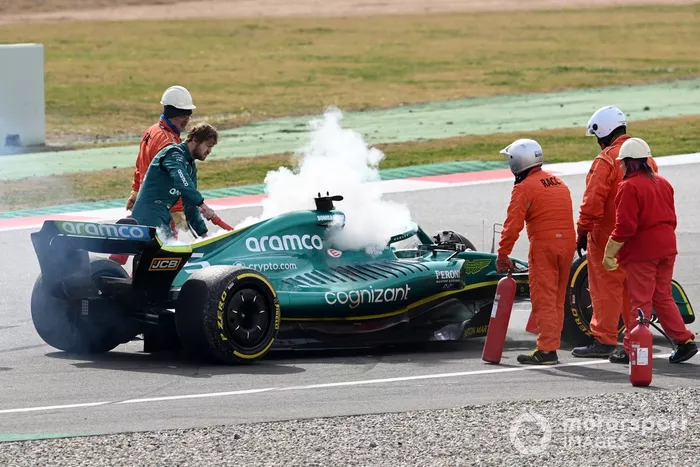 Marshals assist Sebastian Vettel, Aston Martin AMR22, after a technical failure results in smoke