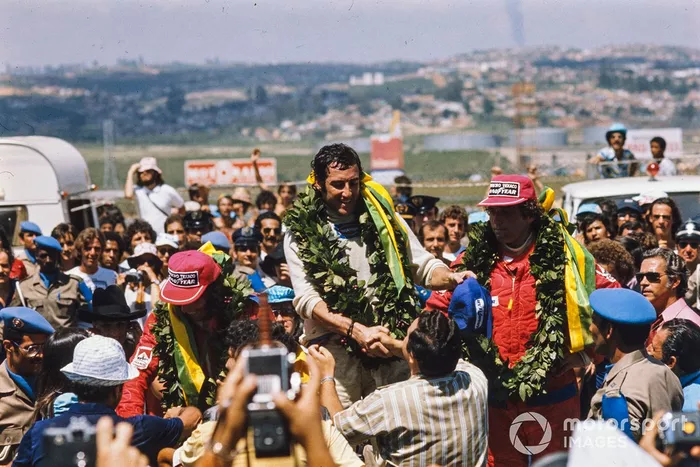 Carlos Pace celebra su primera y única victoria ante su público con su compatriota Emerson Fittipaldi, 2º, y Jochen Mass, 3º.