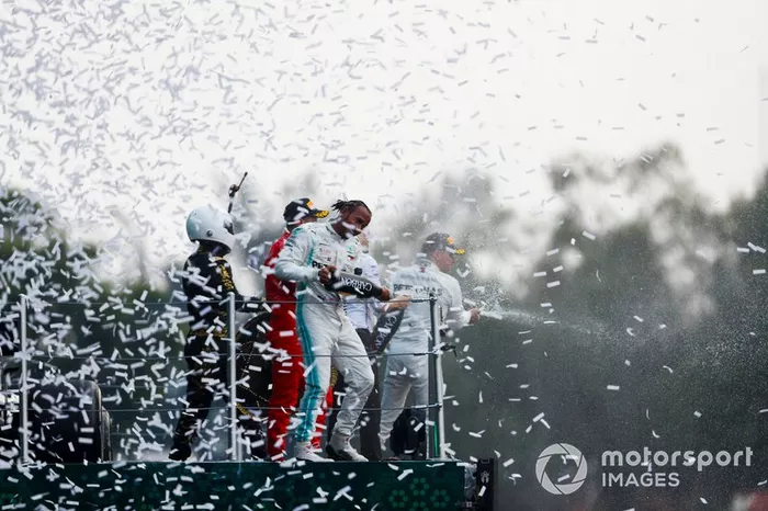 Ganador Lewis Hamilton, Mercedes AMG F1, Sebastian Vettel, Ferrari y Mario Achi, promotor del GP de México, celebran en el podio con el champán