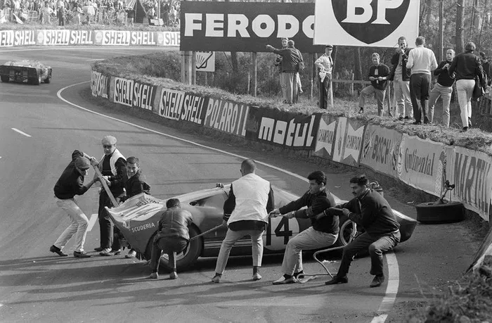 Los marshals trabajan para mover el Ford GT40 de Peter Sutcliffe, Dieter Spoerry después de un accidente