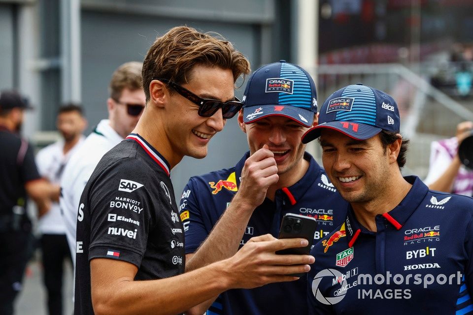 George Russell, Mercedes-AMG F1 Team, pokazuje swój telefon Maxowi Verstappenowi, Red Bull Racing, Sergio Perez, Red Bull Racing 