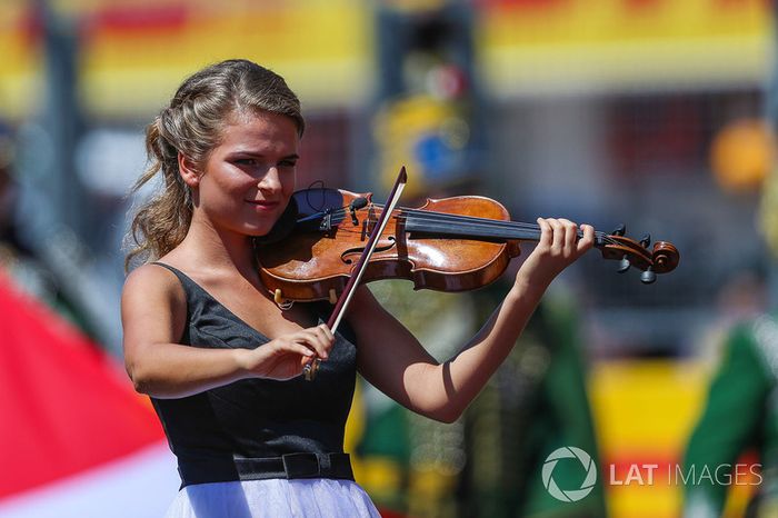 Una chica toca el himno nacional