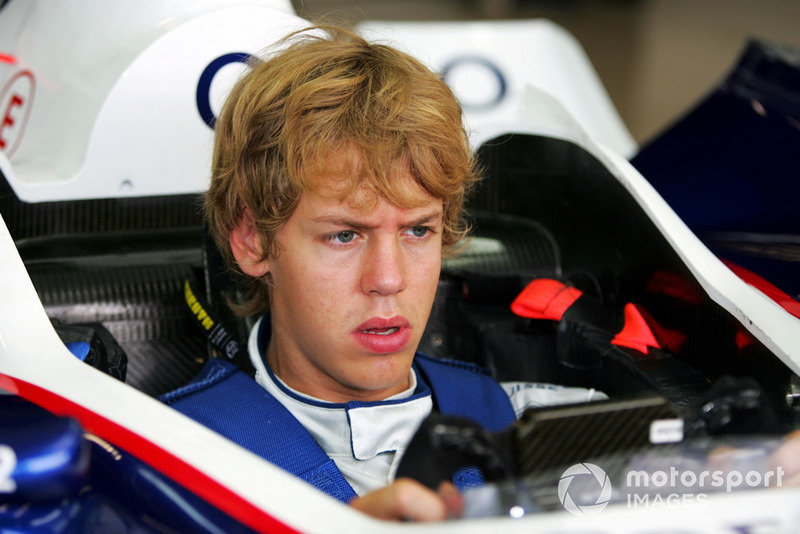 Jóvenes en el coche de Fórmula 1 y pilotos de carreras experimentados en el paddock.