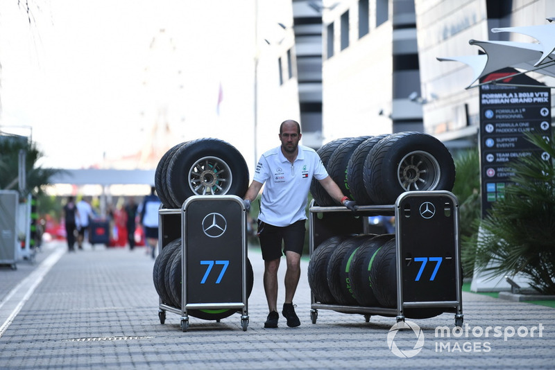 Un mécanicien de Mercedes AMG F1 avec des pneus Pirelli