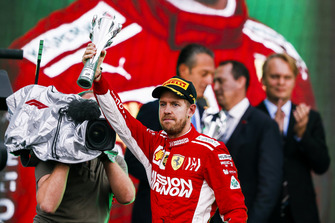 Sebastian Vettel, Ferrari, 2° classificato, alza il suo trofeo sul podio