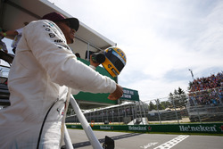 Гонщик Mercedes AMG F1 Льюис Хэмилтон показывает болельщикам подаренный ему шлем Айртона Сенны