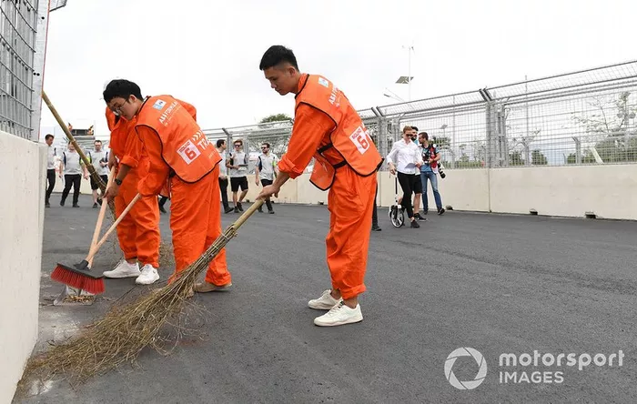 Track workers clean the circuit