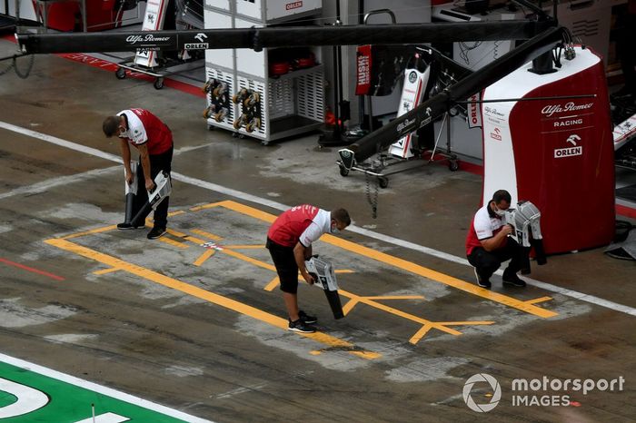 El equipo Alfa Romeo Racing seca el pit lane