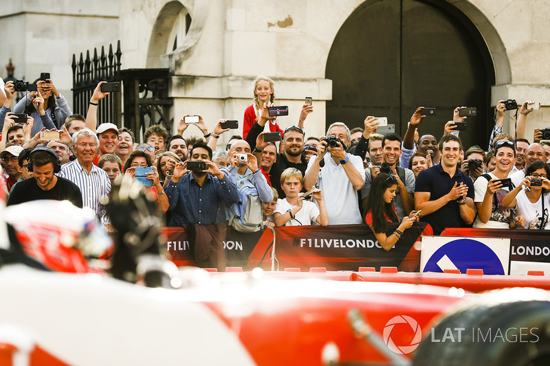 Jenson Button, McLaren, gives a passenger ride to Naomi Campbell in the 2 seater