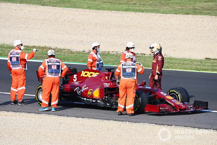 Los oficiales asisten mientras Sebastian Vettel, Ferrari SF1000 se detiene en la pista