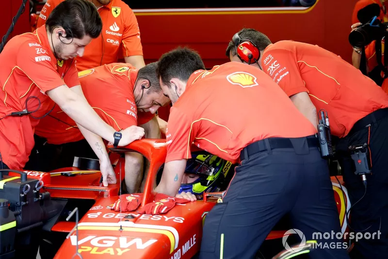 Les mécaniciens aident Oliver Bearman, Ferrari SF-24, à s'installer dans sa voiture.