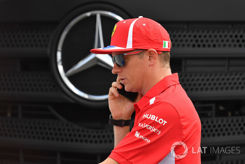 Kimi Raikkonen, Ferrari au téléphone devant un logo Mercedes
