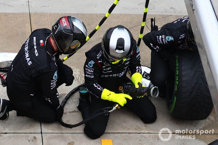 Mecánicos cambiando la rueda en el monoplaza de Mercedes 