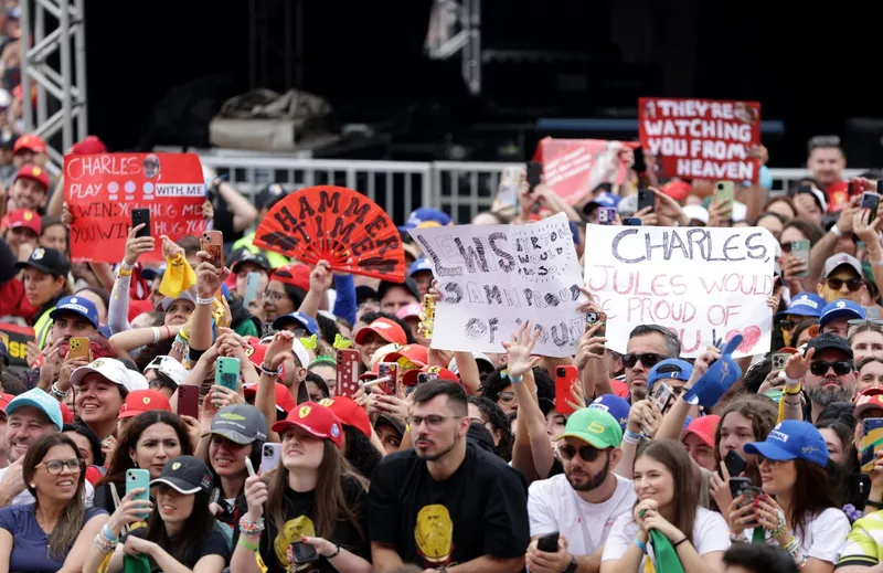 Les fans brandissent des pancartes de soutien à la Scuderia Ferrari dans la fan zone.