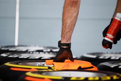 Un mecánico pinta marcas direccionales en los neumáticos Pirelli