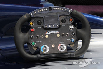 KV Racing Technology steering wheel up close, notice the green push to pass button on the bottom left