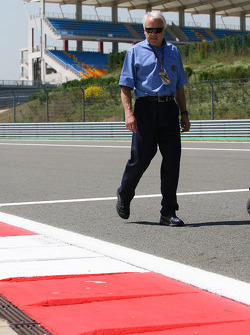Charlie Whiting, Délégué à la sécurité FIA, Directeur de course et Starter Officiel inspecte le circuit
